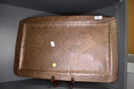 An arts and crafts style copper tray with lily imagery