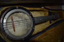 An early 20th Century banjo ukulele in need of some restoration to skin etc, in a violin case