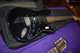 A Squier (by Fender) Stratocaster electric guitar (japanese made serial number O015498), in padded