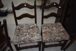 A pair of reproduction ladder back dining chairs
