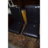 A pair of modern dark brown leather effect dining chairs on wood legs