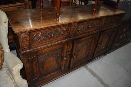 A late 20th century oak sideboard in the Jacobean style, having 3 frieze drawers and cupboard with