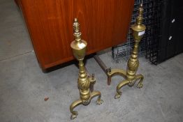 A pair of Victorian fire dogs having brass and cast design