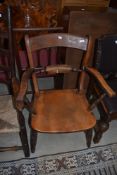 A late 1th or early 20th Century rail back carver chair having turned legs and H stretcher