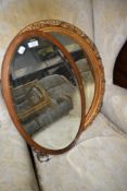 Two vintage oval wall mirrors