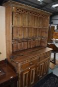 A traditional pine dresser having fret top Delft rack over drwers and cupboards, w 131cm