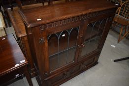 A traditional style bookcase having leaded doors, width approx. 102cm