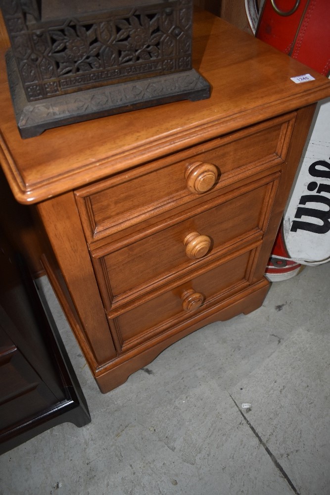 A modern stained rubber wood bedside chest of 3 drawers