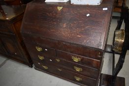 A 19th century oak bureau of traditional fall front design with concealed section and 2 short and