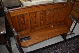 An early 20th century pitch pine pew of traditional ecclesiastical design, numbered 20, w 125cm