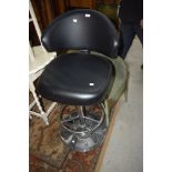 A modern chrome and black vinyl upholsterd kitchen/bar stool