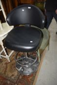 A modern chrome and black vinyl upholsterd kitchen/bar stool