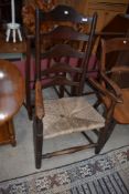 A period oak rush seated ladder back carver chair