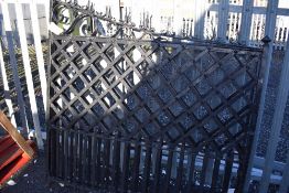 A set of wrought iron driveway or entrance gates with cast iron pillar posts