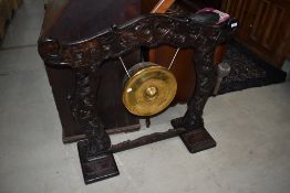A late Victorian dark oak frame dinner gong having brass roundel