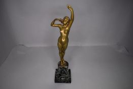 An early 20th century bronze figurine depicting nude lady stretching on green marble base, incised