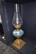 A late Victorian oil lamp having a blue honeycomb style well with cast iron base