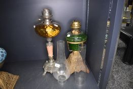 Two late Victorian oil lamps including yellow and green glass wells with cast metal bases