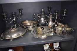 A selection of silver plated wares including tea pot, candle stems and serving dish