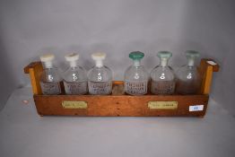 A set of laboratory bottles in holder having etched labels