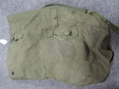 A large green canvas army style kit bag or rucksack.