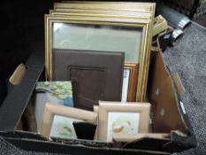 An assortment of frames, watercolours and an embroidery.