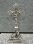 A cast metal crucifix having mourning pair to base.