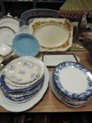 A selection of plates and platters including milk glass and blue and white ware.