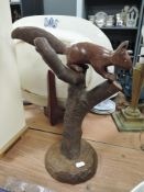 A carved mahogany squirrel on fruit wood branch,on oak base.