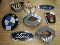 Eight car badges including ford and MG.
