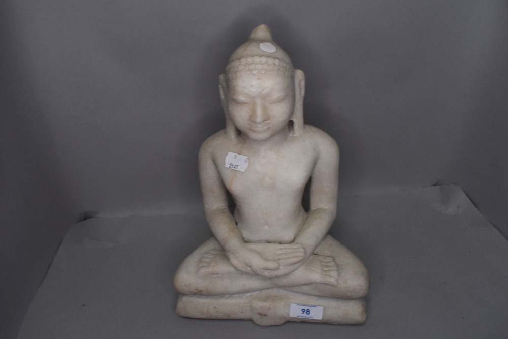 A large hand carved stone figure of a seated Tibetan style Shakyamuni Buddha