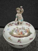 An antique KPM punch bowl having cherub to top and hand tinted design of classical scenes and flora.