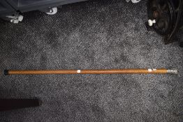 A Malacca walking cane or stick having a chase worked knop testing as silver