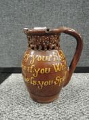 A treacle coloured slipware puzzle jug circa 19thC, having inscription of 'Gentlemen now try your