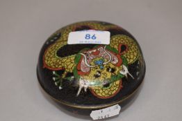A Japanese cloisonne lidded dish or bowl decorated with mythical dragon on black ground