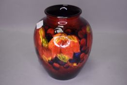 An early 20th century Flambe vase by Moorcroft decorated with autumnal leaves