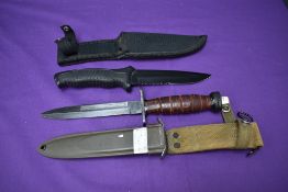 A Made in China Fighting Knife with rubberized grip and canvas scabbard, overall length 28cm along