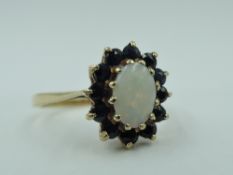 An opal and sapphire oval cluster dress ring in a claw set basket mount on a 9ct gold loop, size N &