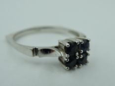 A four stone sapphire dress ring on a shaped white metal loop stamped 585, size P & approx 2.8g