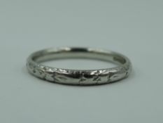A white metal wedding band stamped platinum having moulded decoration, size I & approx 2.7g