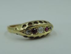 A ruby and diamond chip dress ring having boat gallery mount on a yellow metal loop stamped 18ct,
