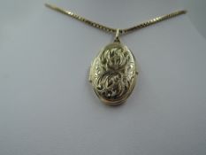 A 9ct gold oval locket having engraved scroll decoration to front, on a 9ct gold box chain, approx