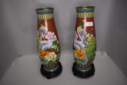A pair of Chinese cloisonne vase having mirror image of peacocks in fantasy landscape