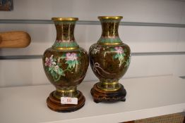 A pair of Chinese cloisonné vases having brown ground with floral decoration. Label to underside