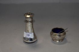 Two hallmarked silver condiments, comprising pepperette and salt with blue glass liner.