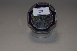 A Perthshire glass close-pack milliefiori paperwight, purple cased with wheel-cut 'windows' re-