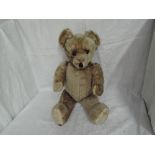 A mid 20th century straw filled yellow plush Teddy Bear having plastic eyes, stitched nose and