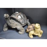A modern cast-resinous model of a tortoise, sold together with a smaller tortoise form money bank