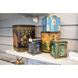 A group of decorative tin tea canisters, oriental themed designs