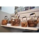 A group of five copper kettles, Victorian and later, various sizes.